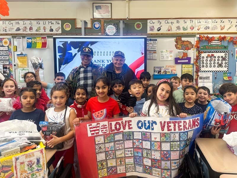 Students holding banner with veterans.