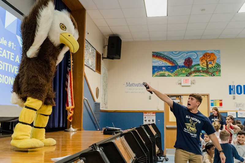 students watch presentation with mascot