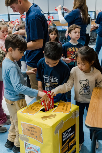 students put paper in a box with a hole in it