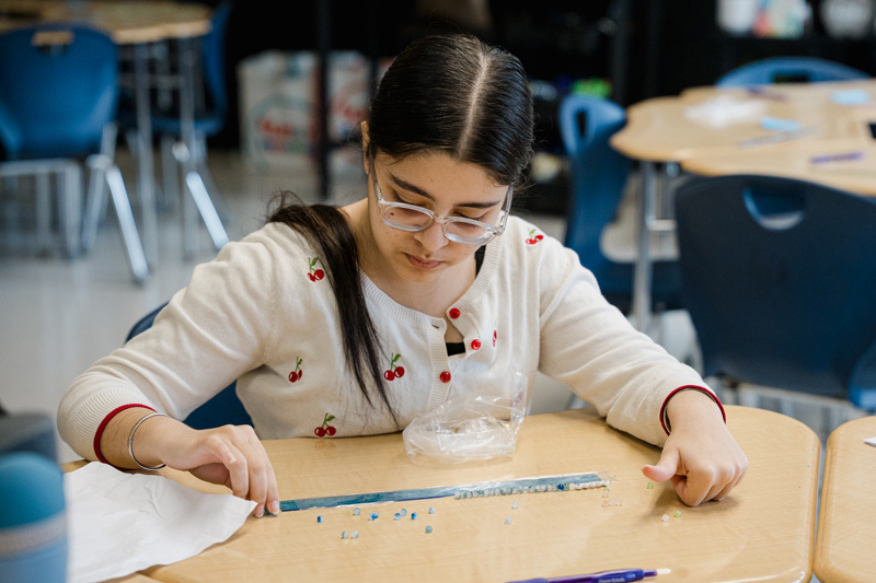 student focused on drawing with a pencil on white paper