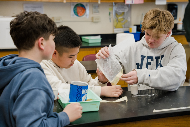 student focused on drawing with a pencil on white paper