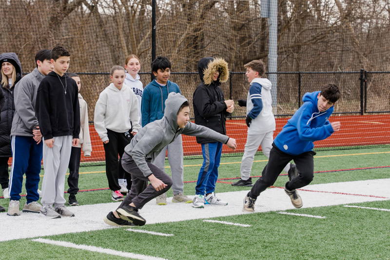 students running across football field in a race