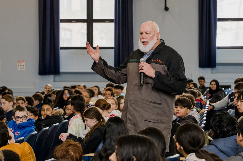 older man speaking in front of class