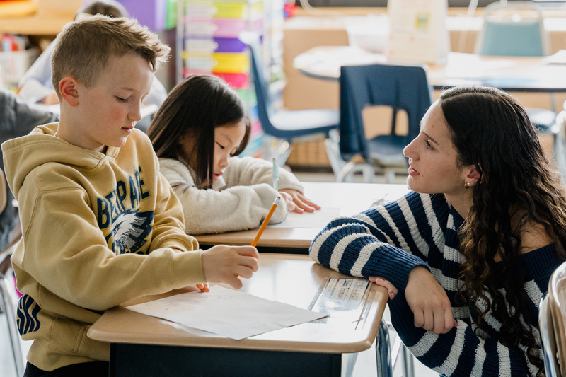 people read books to seated children in a classroom.
