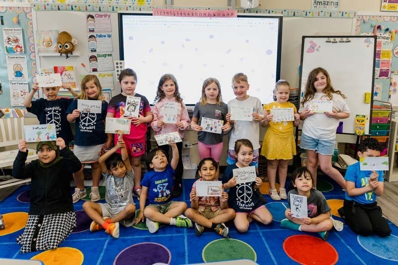 Group photo of students proudly holding their art.