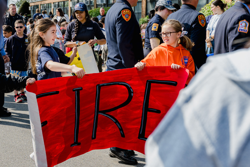 Community event at Central Boulevard Elementary with children and firefighters enjoying a meal together, fostering relationships and celebration.