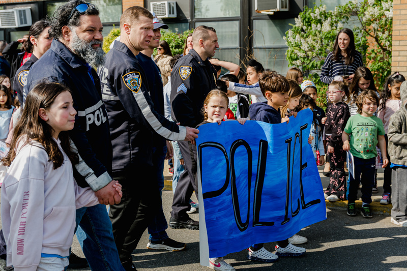 Community event at Central Boulevard Elementary with children and firefighters enjoying a meal together, fostering relationships and celebration.