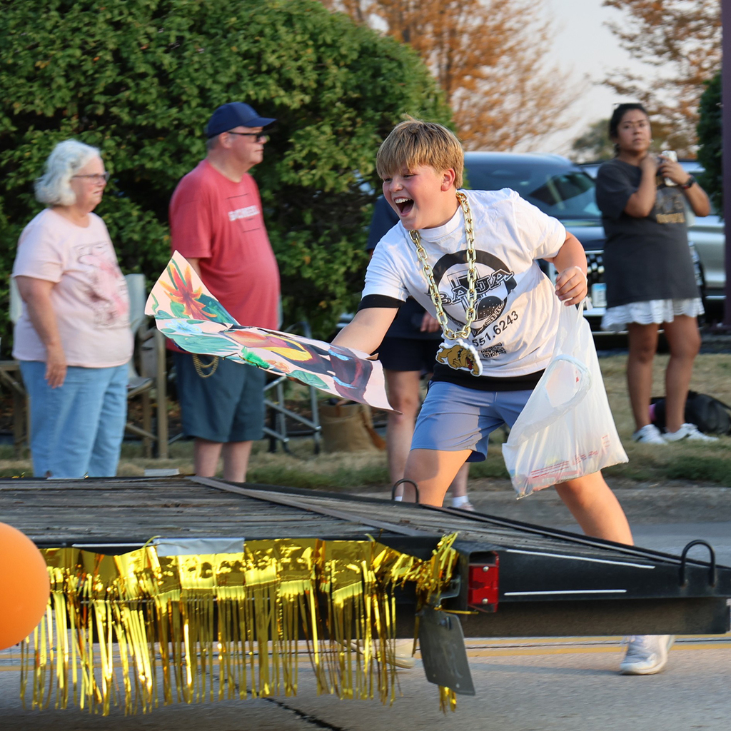 Boys catches artwork flying of a float in midair