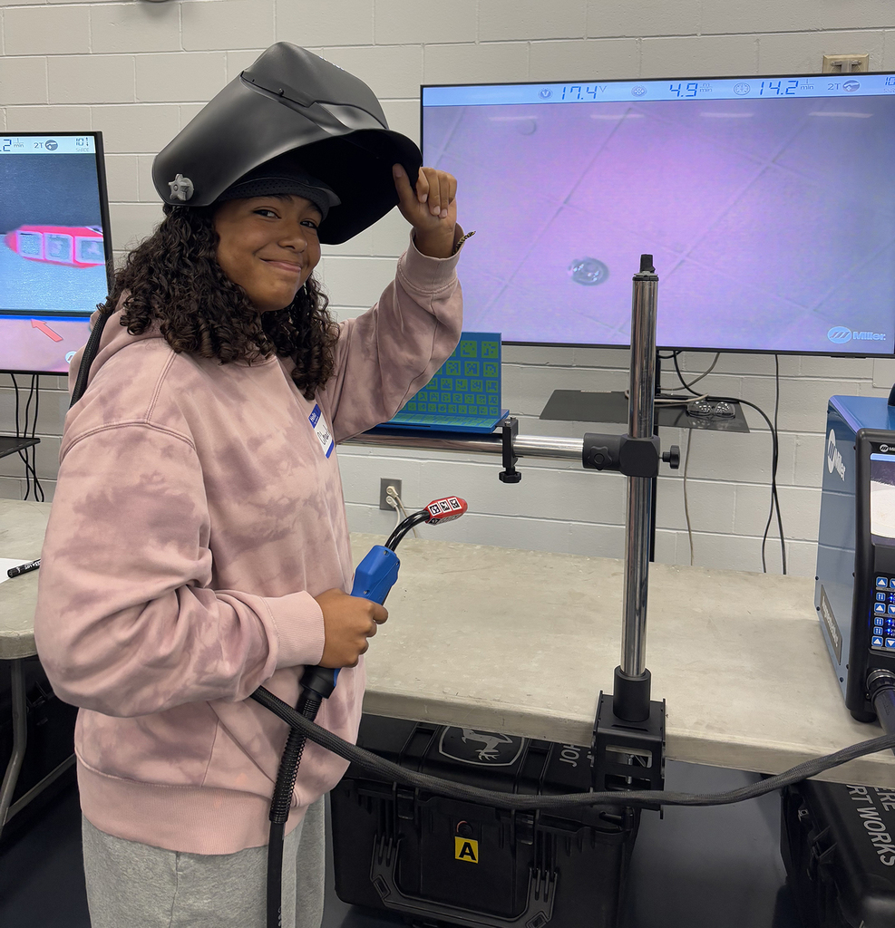 Girl with welding headgear getting ready to weld online