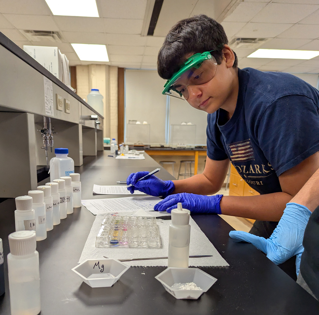 Student exploring acids and bases in the St. Ambrose chemistry lab