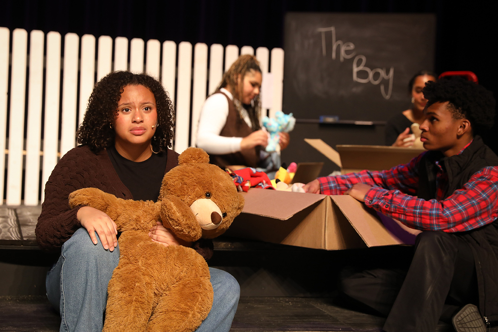 Student looking into the distance with teddy bear
