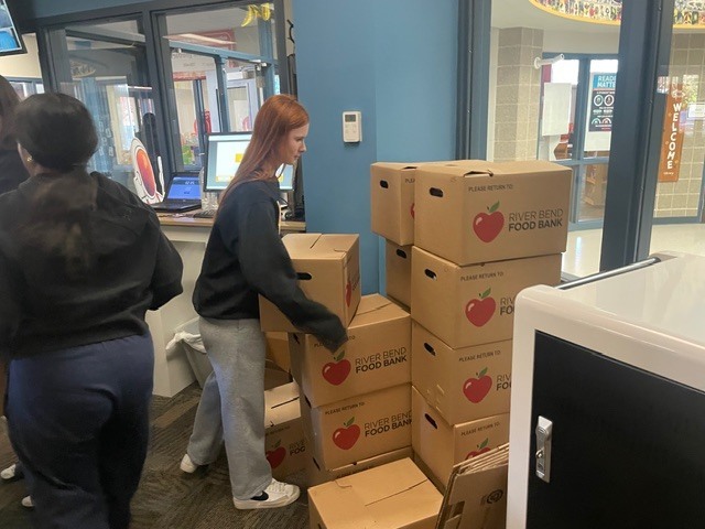 Student moving a stack of boxes