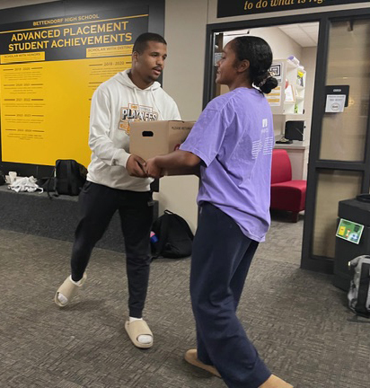 Students moving boxes to the truck