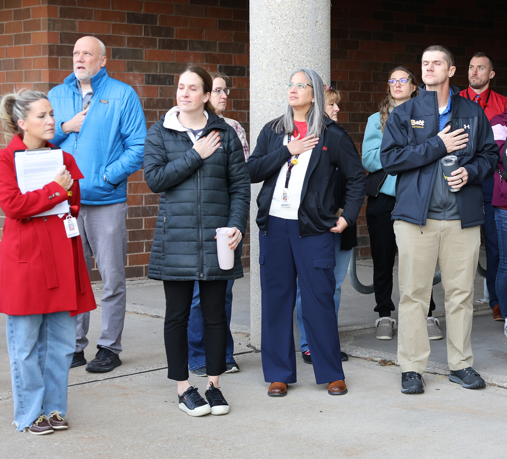 Staff honoring the flag during Taps