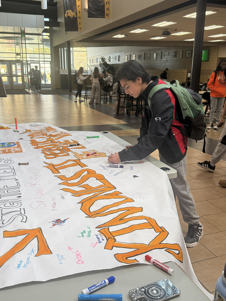 A HS student signing a pledge to be kind.