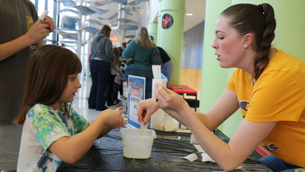 Carver College of Medicine student MT Gehrmann demonstrates how to make casts during a STEM event at the Family Museum in Bettendorf in 2024.