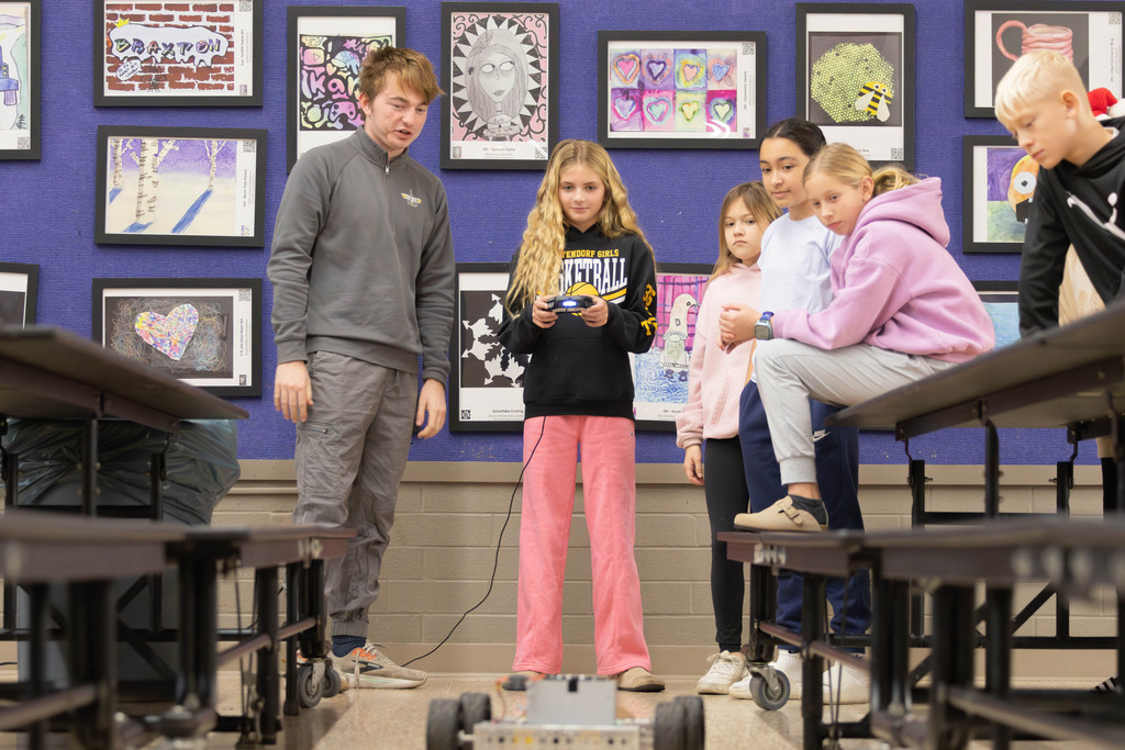 A Paul Norton student operates a robot