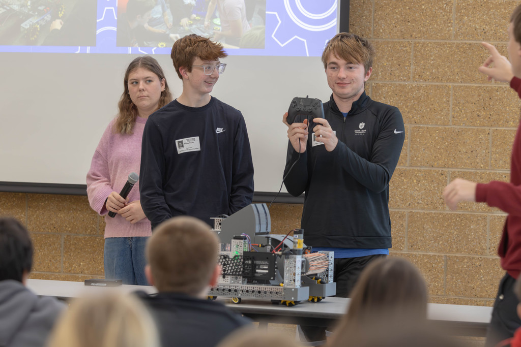 HS students showing their robot and remote