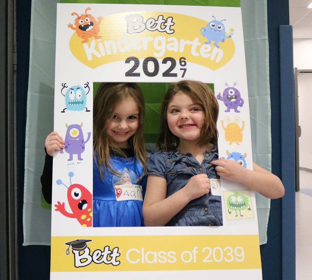 Students posing for a picture with a Sneak Peak photo frame