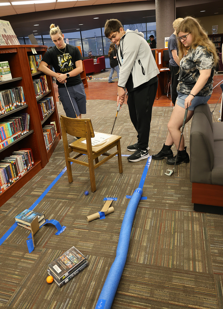 Library Mini Golf - Student working through a golf maze