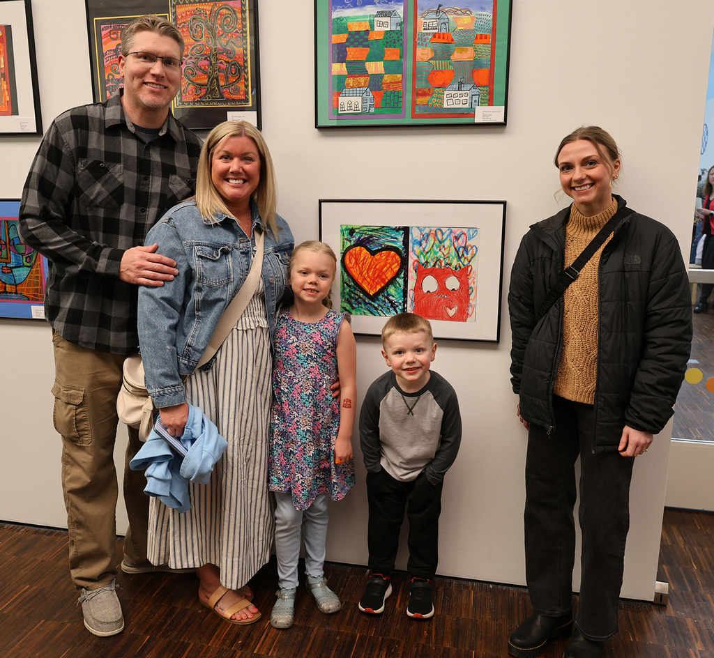 Elementary art showcase at The Figge - a family posing in front of their daughter's artwork