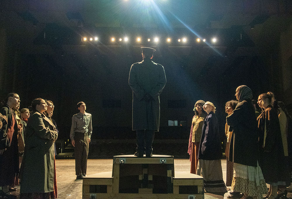 Officer on a platform with the villagers around him