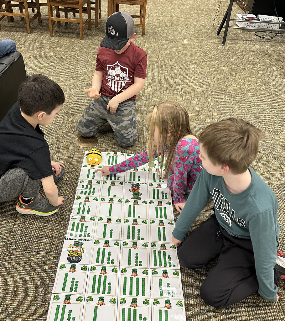 Students playing a St. Partirck themed game with a ladybug robot.