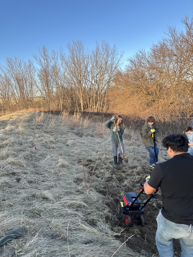 Students working on clearing up some land to plant seeds.