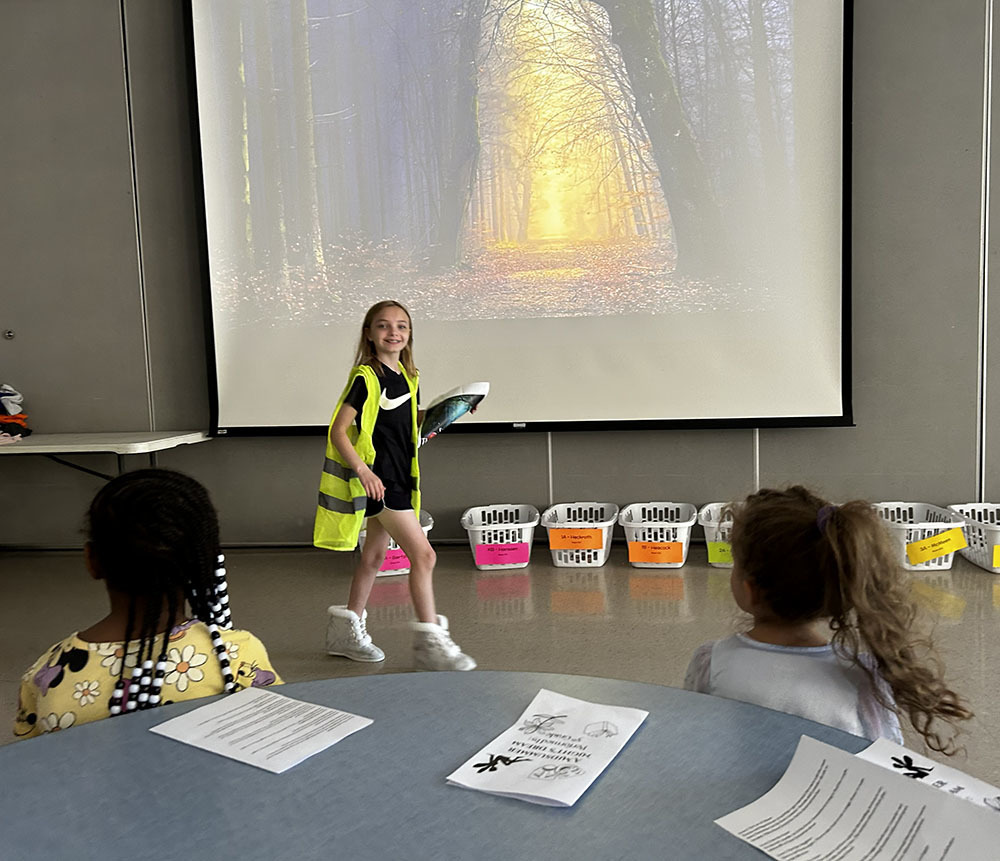 Girl in a safety vest walking past the sunlit  path in the woods