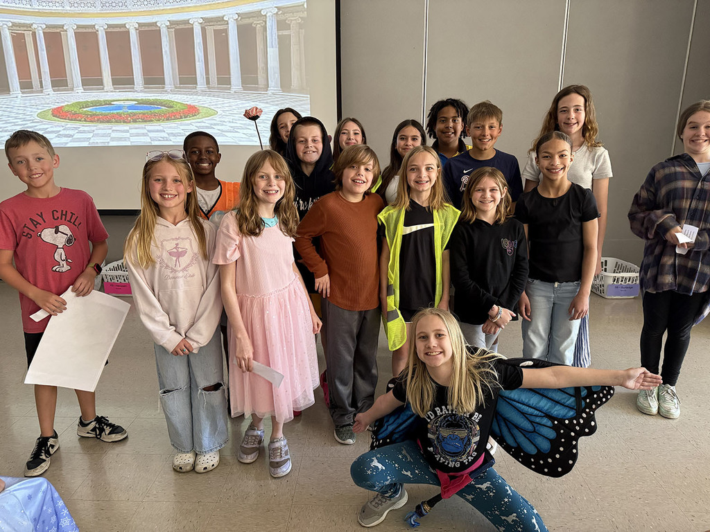The cast from one of the plays stands for a pictures in front of the royal court. Student dressed as a butterfly poses in front.
