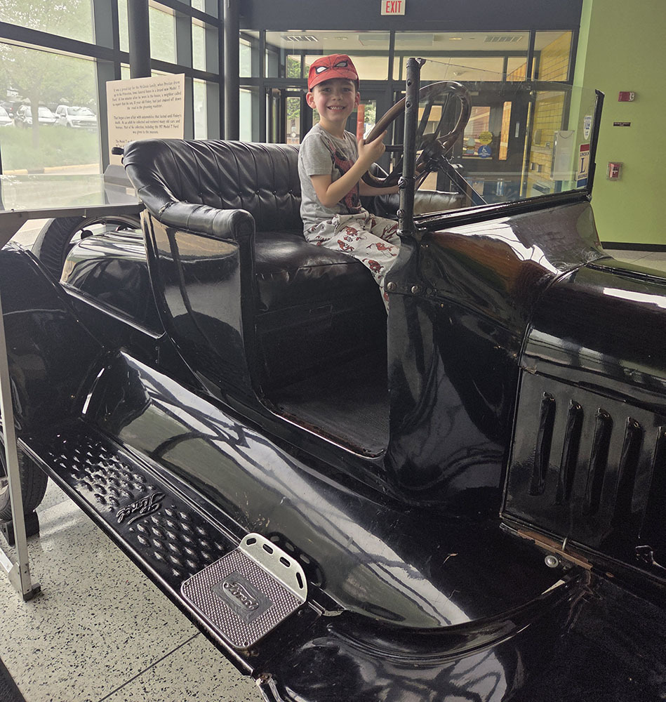 Young boy smiling on antique car