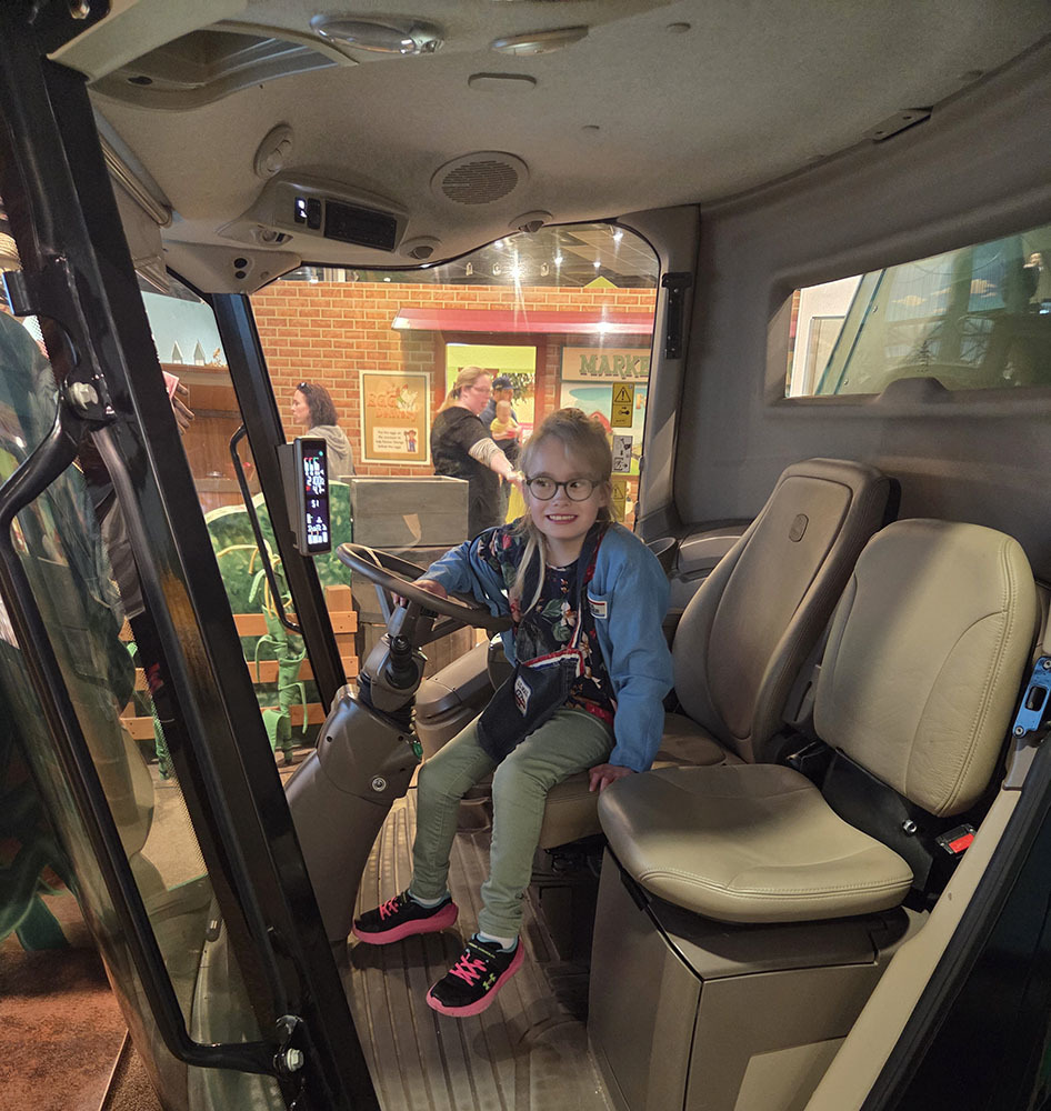 A young dirl "driving" a combine