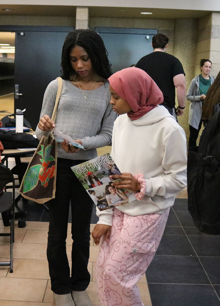 Two girls looking over information