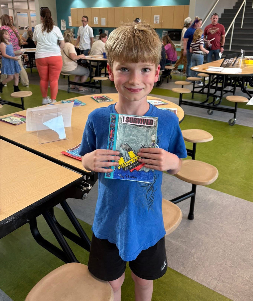 Boy holding a self created book titles "I Survived"