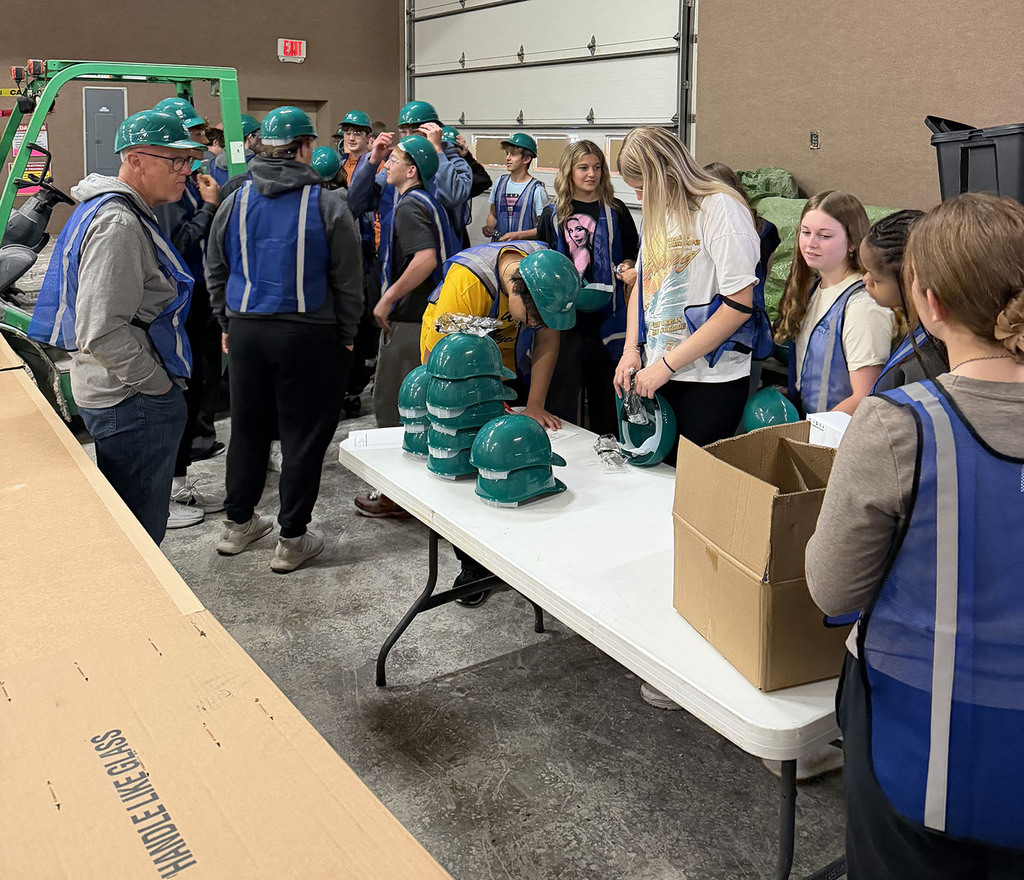 Students gearing up with helmets and safety vests.