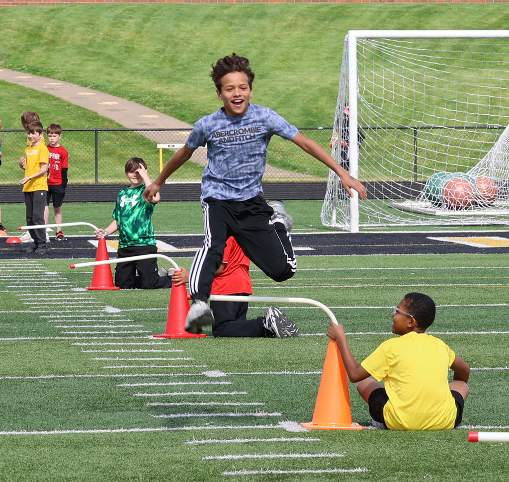 A boy jumping a hurdle