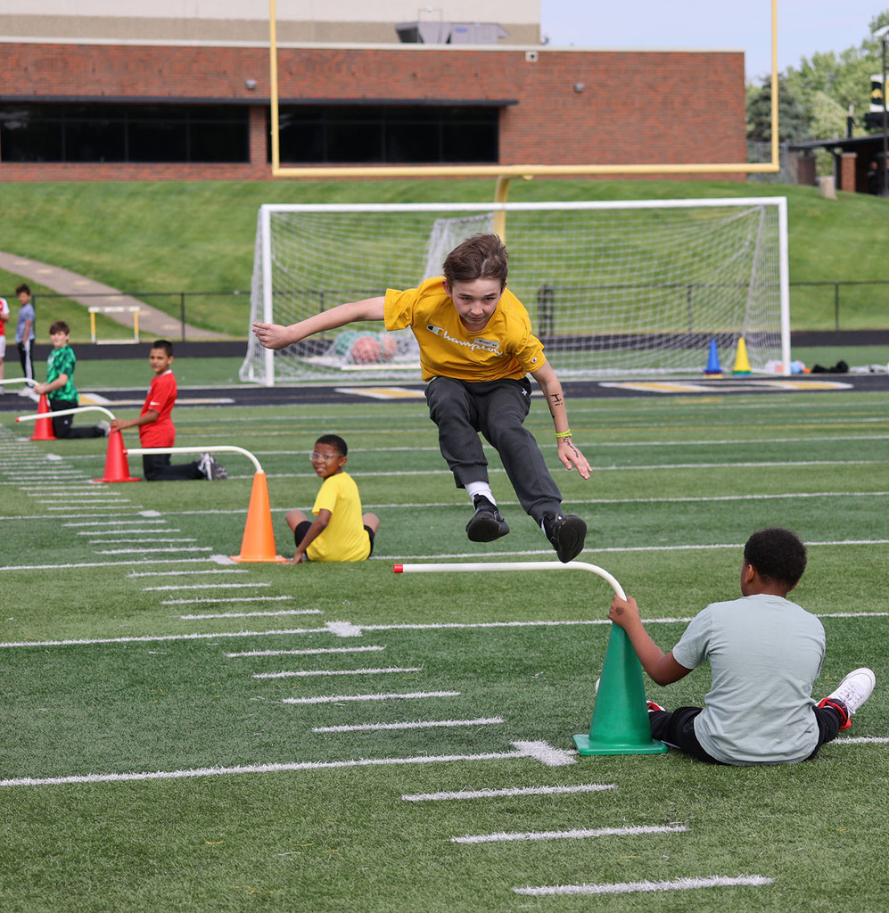 A boy jumping a hurdle