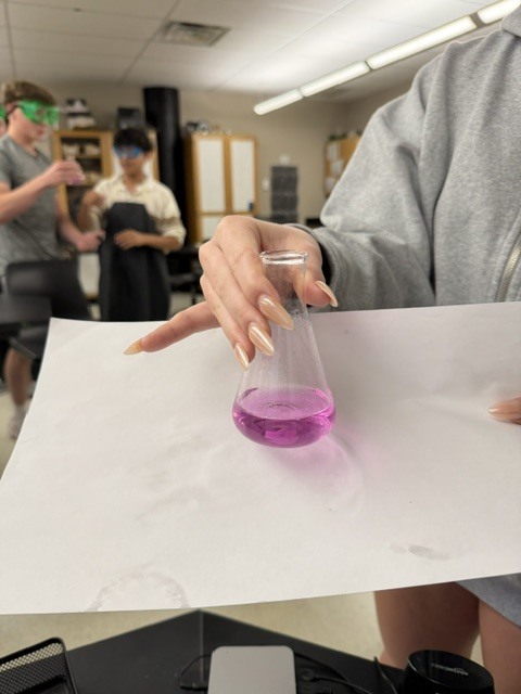 Student with vial of pink liquid