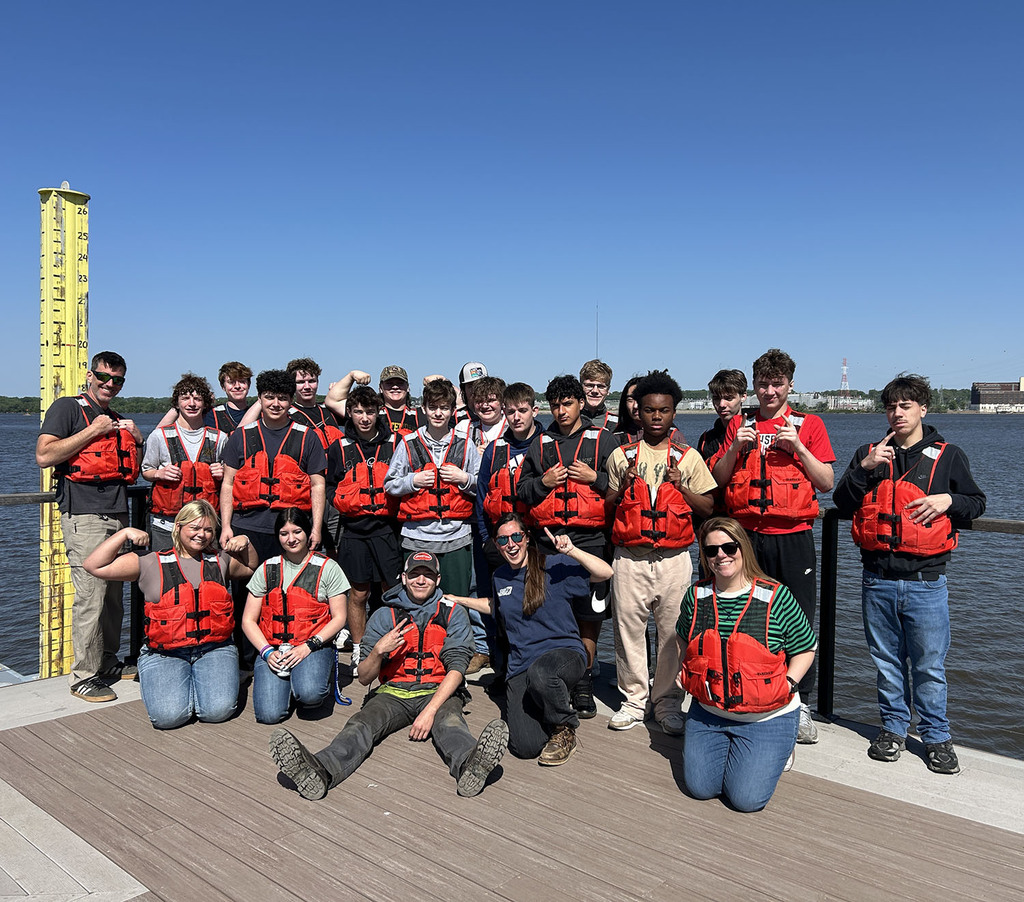 Students posing for a picture on a dock.