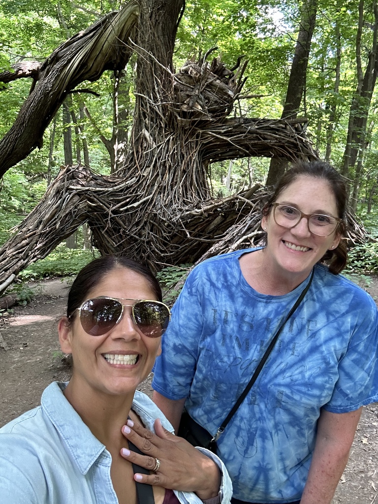 Nicole & Stacey take a selfie with a troll blending in with the trees.
