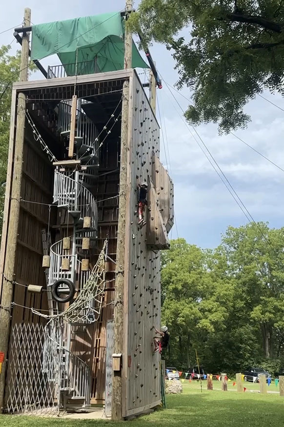 Simon and Tyson Severson climbing a rock wall at camp.