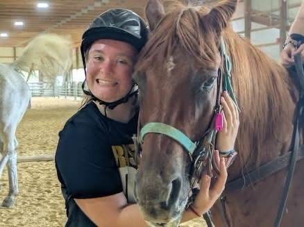 Abigail hugging a horse