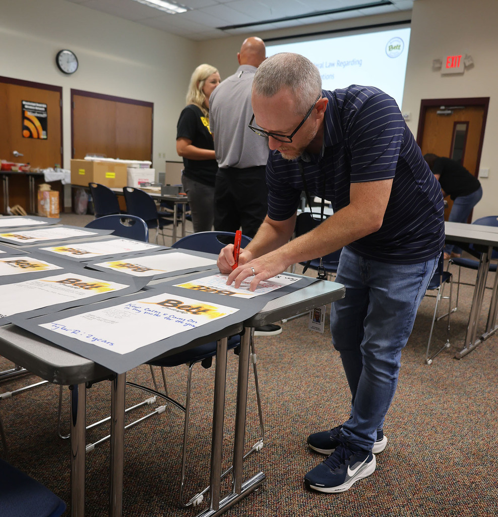 Technolgy Director Ben Reller writing a note for another administrator.