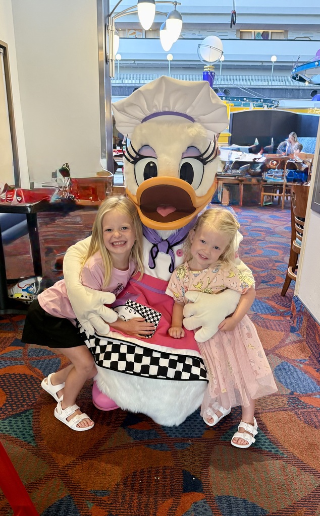 Lola and her sister with a duck chef at Disney World.