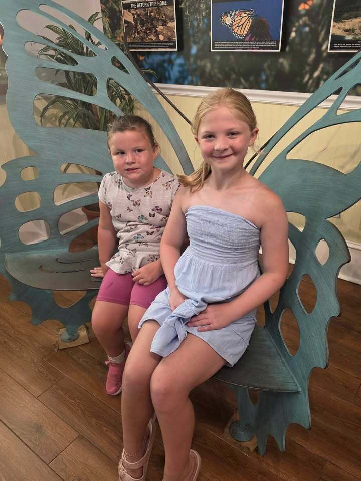 Lydia and Savannah sitting on a butterfly shaped bench