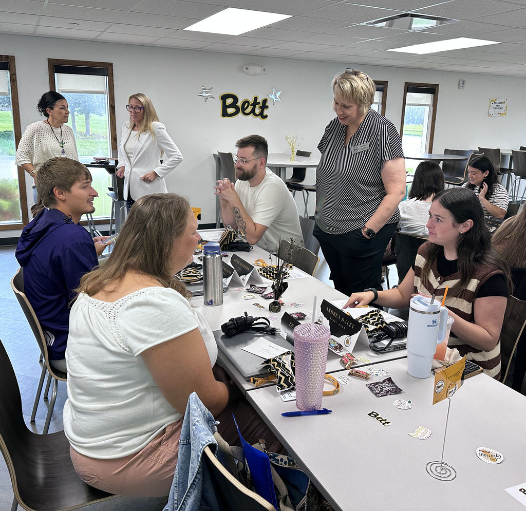 Jayme Olson, Executive Director of Curriculum & Instruction visiting with a table of new teachers