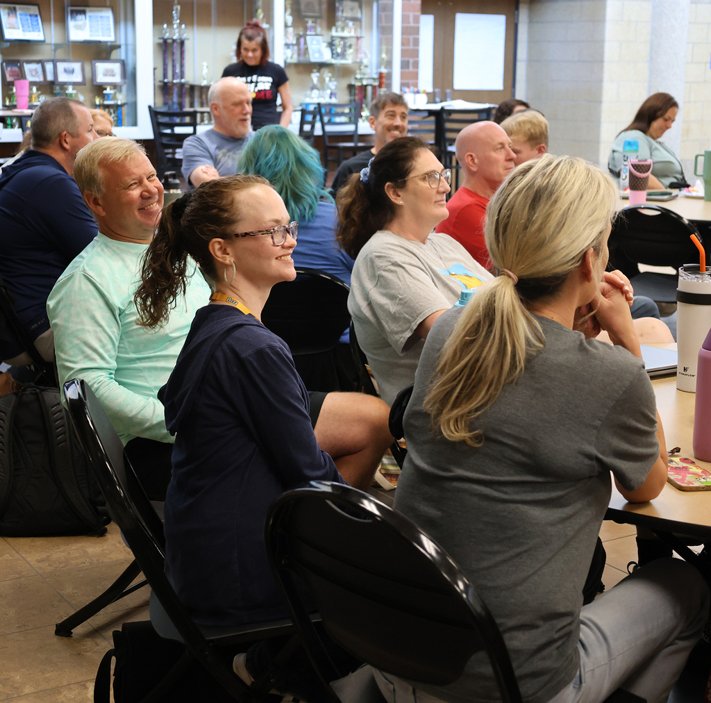Staff having fun as hear AI music and lyrics representing each decade staff attended high school.