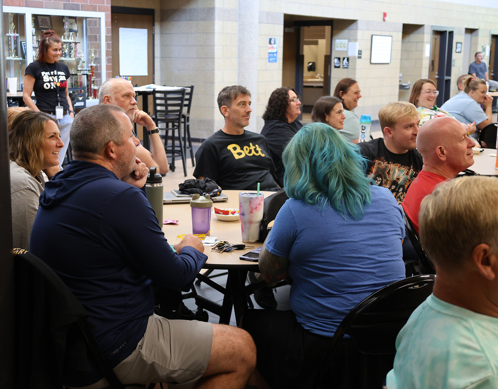 Staff having fun as hear AI music and lyrics representing each decade staff attended high school.