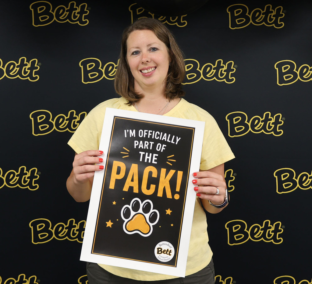 Genevieve Russo with a sign: I'm officially part of the pack! Paw print. Bettendorf Community School District logo with Bett graphic
