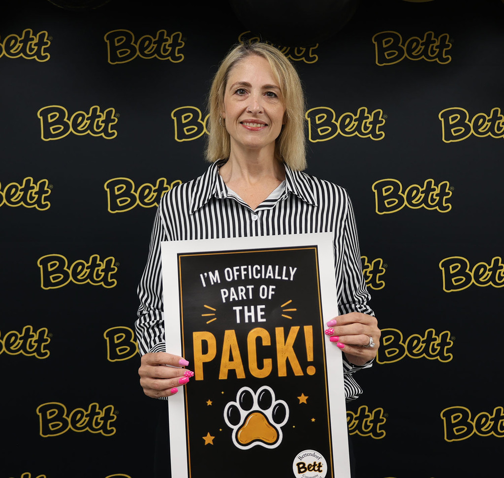 Kimberly Davis with a sign: I'm officially part of the pack! Paw print. Bettendorf Community School District logo with Bett graphic